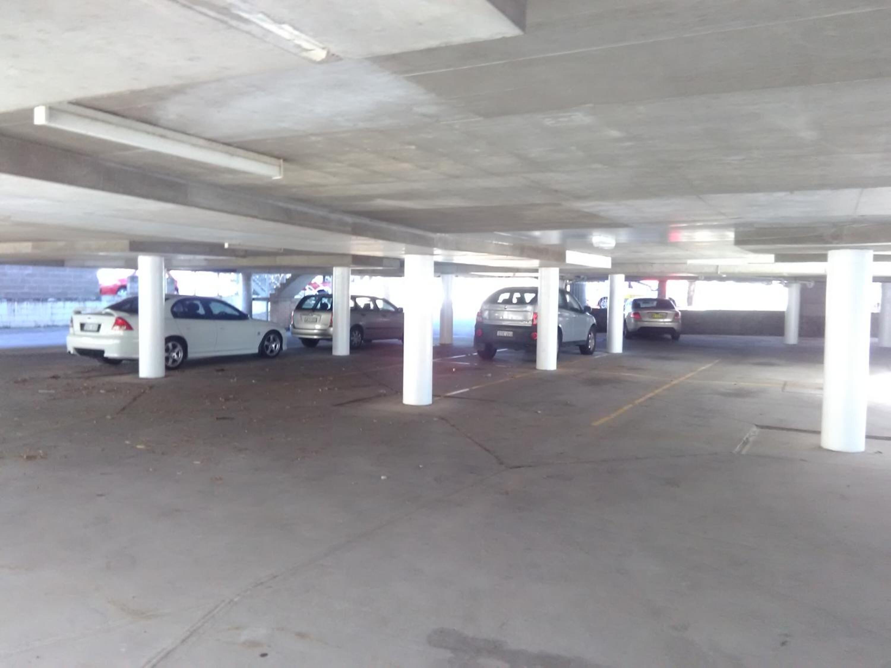 A multi-level parking garage with several cars parked under the structure.