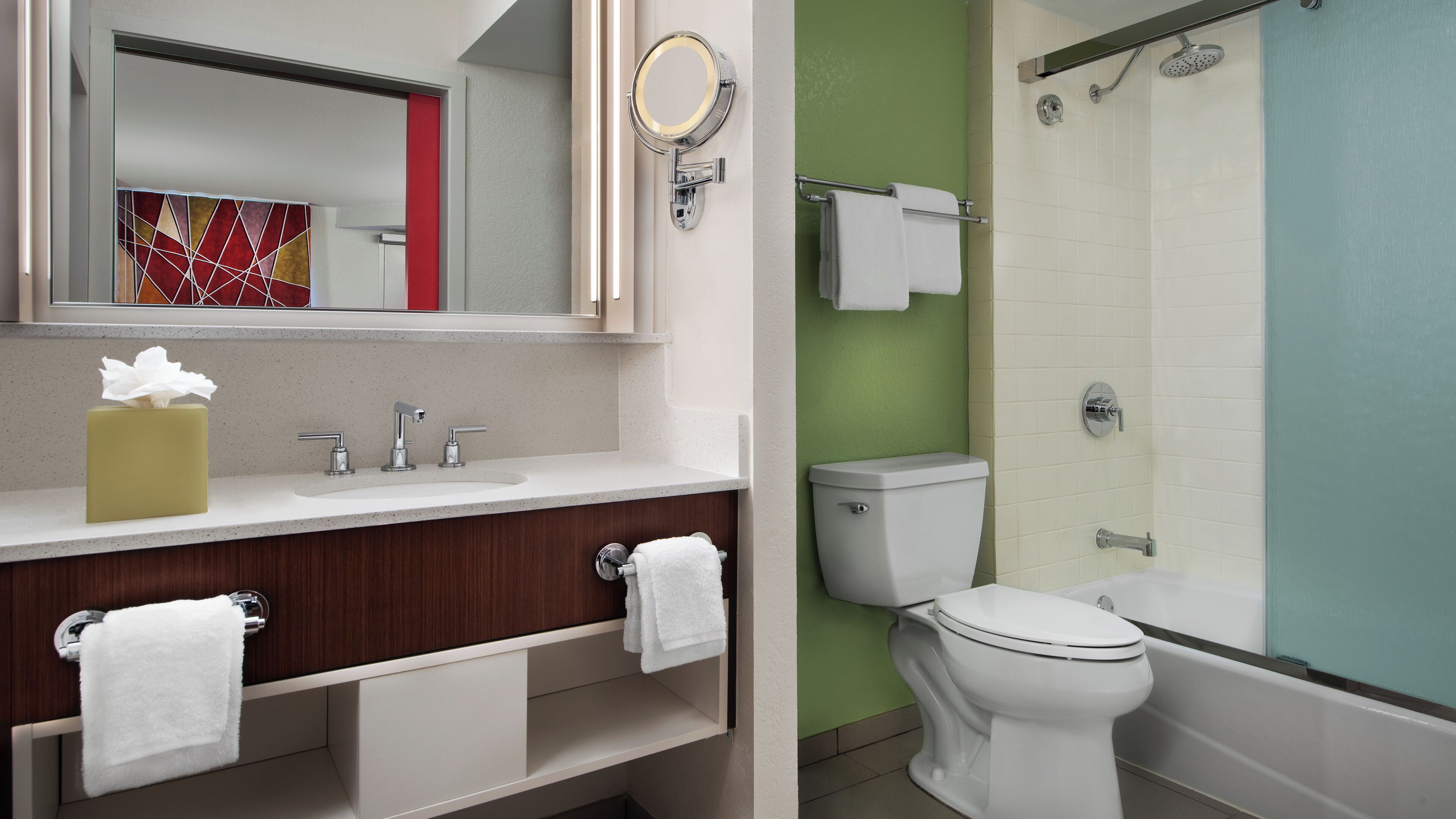 A bathroom with a sink, mirror, toilet, and shower.