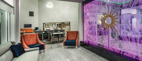 A modern interior with a reception desk, seating area, and a decorative wall with a sun motif.