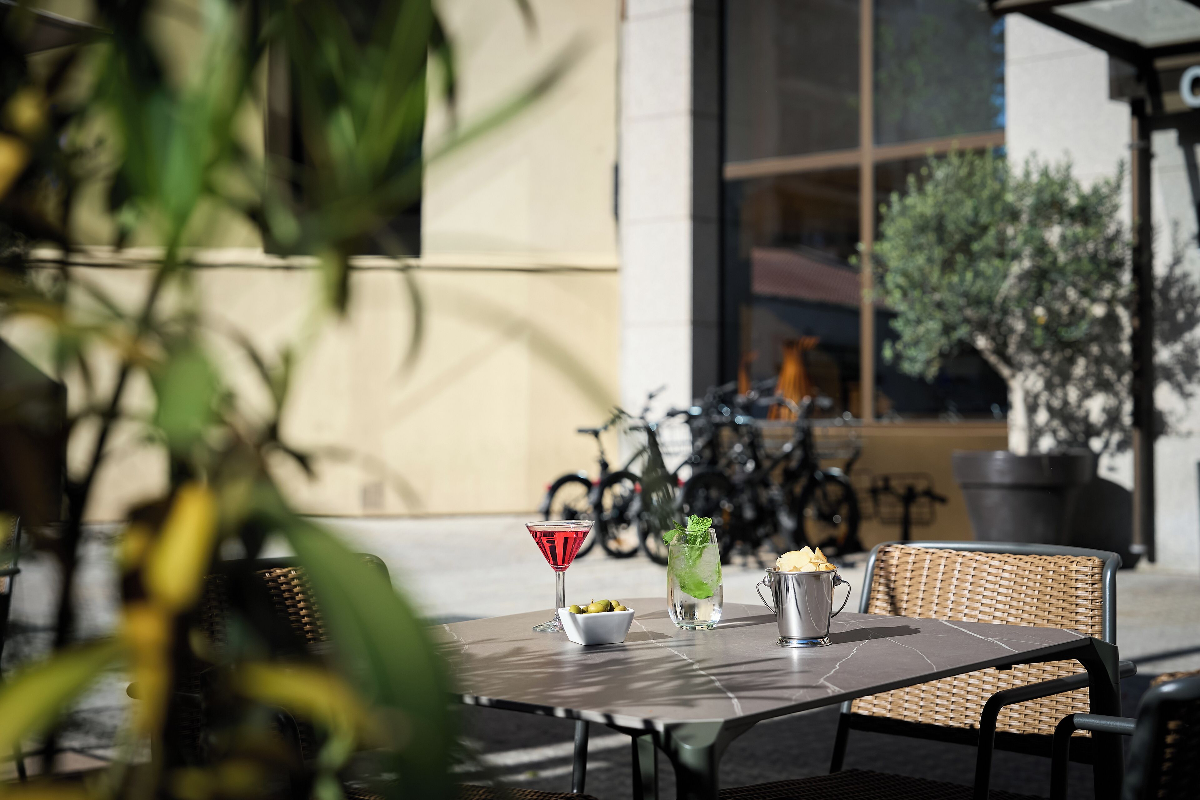 An outdoor seating area with a table, chairs, and a drink.