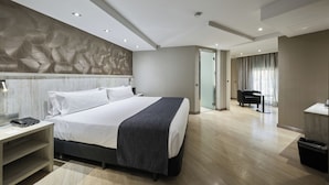 A modern hotel room with a large bed, bedside table, and a desk area. - Catalonia Sagrada Familia (Barcelona)