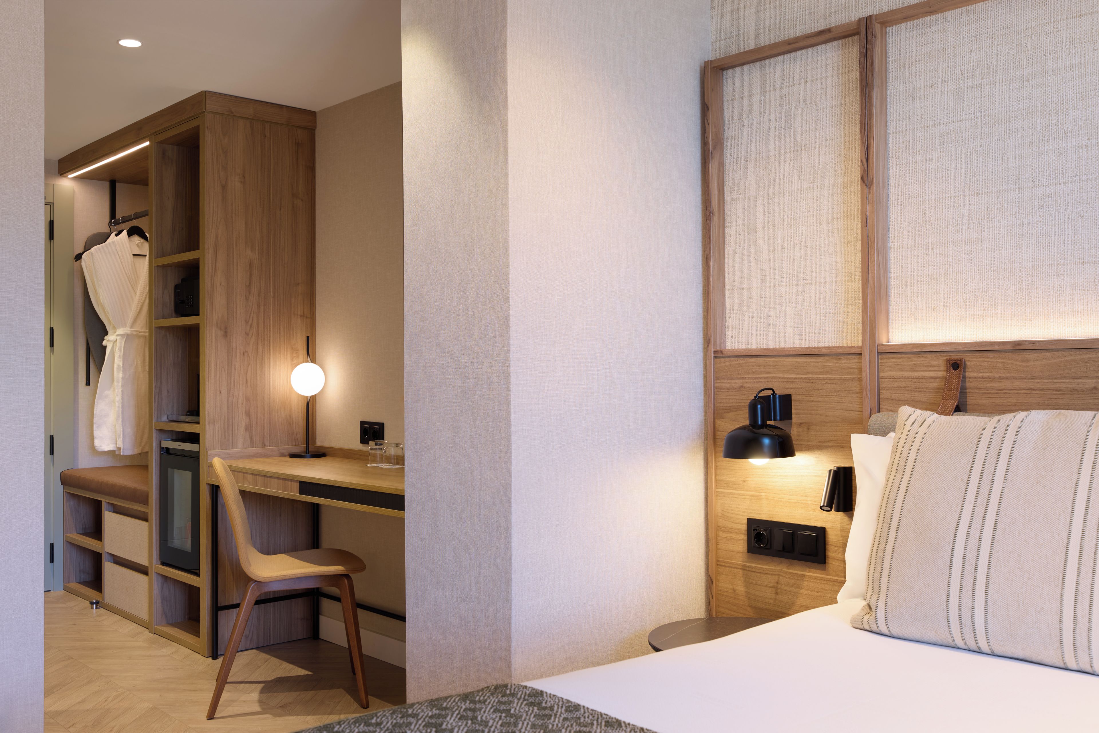Une chambre d’hôtel comprenant un lit, un bureau, une chaise et une armoire.
