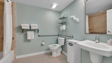 A bathroom with a toilet, sink, and shower area.