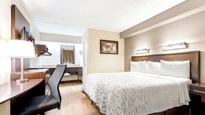 A hotel room with a bed, desk, chair, and a mirror. - Red Roof Inn PLUS+ Mt Pleasant - Patriots Point (Mount Pleasant)