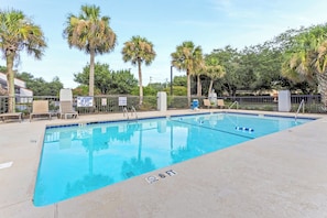 A swimming pool with clear blue water, surrounded by palm trees and lounge chairs. - Red Roof Inn PLUS+ Mt Pleasant - Patriots Point (Mount Pleasant)