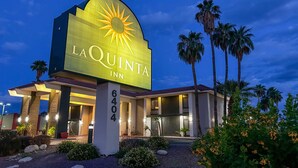 Un hotel con un gran letrero iluminado que dice "LA QUINTA INN" y el número "6404" en el edificio.