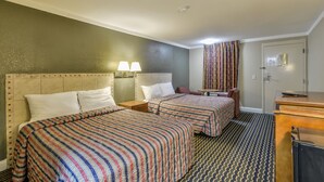 A hotel room with two beds, a desk, and a dresser. - Wake Inn (Raleigh)