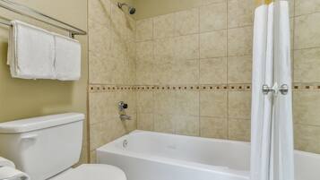 A bathroom with a bathtub, toilet, and shower.