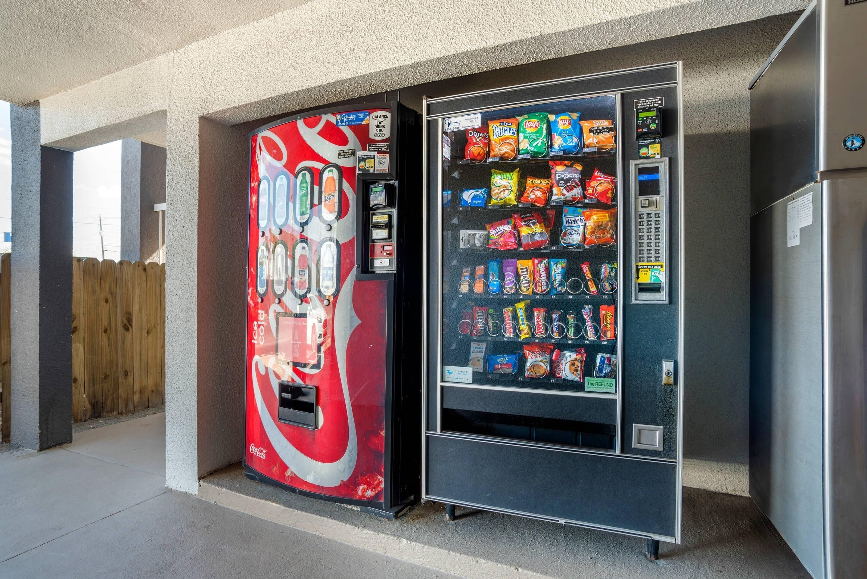 A vending machine with a Coca-Cola logo and a snack vending machine with various snacks.