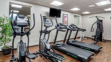 A gym with treadmills, elliptical machines, and a weight machine.