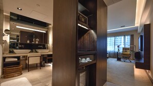 A modern hotel room with a large mirror, a built-in fireplace, a desk, and a large window. - Furama Hotel Dalian (Dalian)
