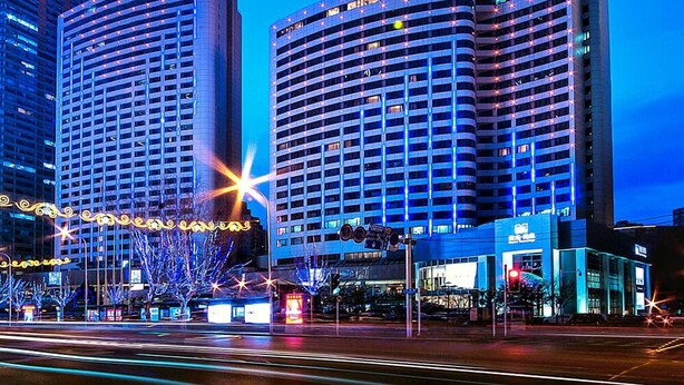 A modern hotel with a curved facade, multiple floors, and a prominent 'SP' logo on the top building. - Furama Hotel Dalian (Dalian)