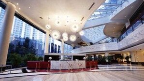 A spacious lobby with a high ceiling, modern chandeliers, and a red carpet leading to a reception desk. - Furama Hotel Dalian (Dalian)