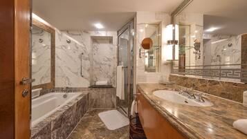Un baño moderno con una bañera grande, dos lavamanos y una cabina de ducha de vidrio.