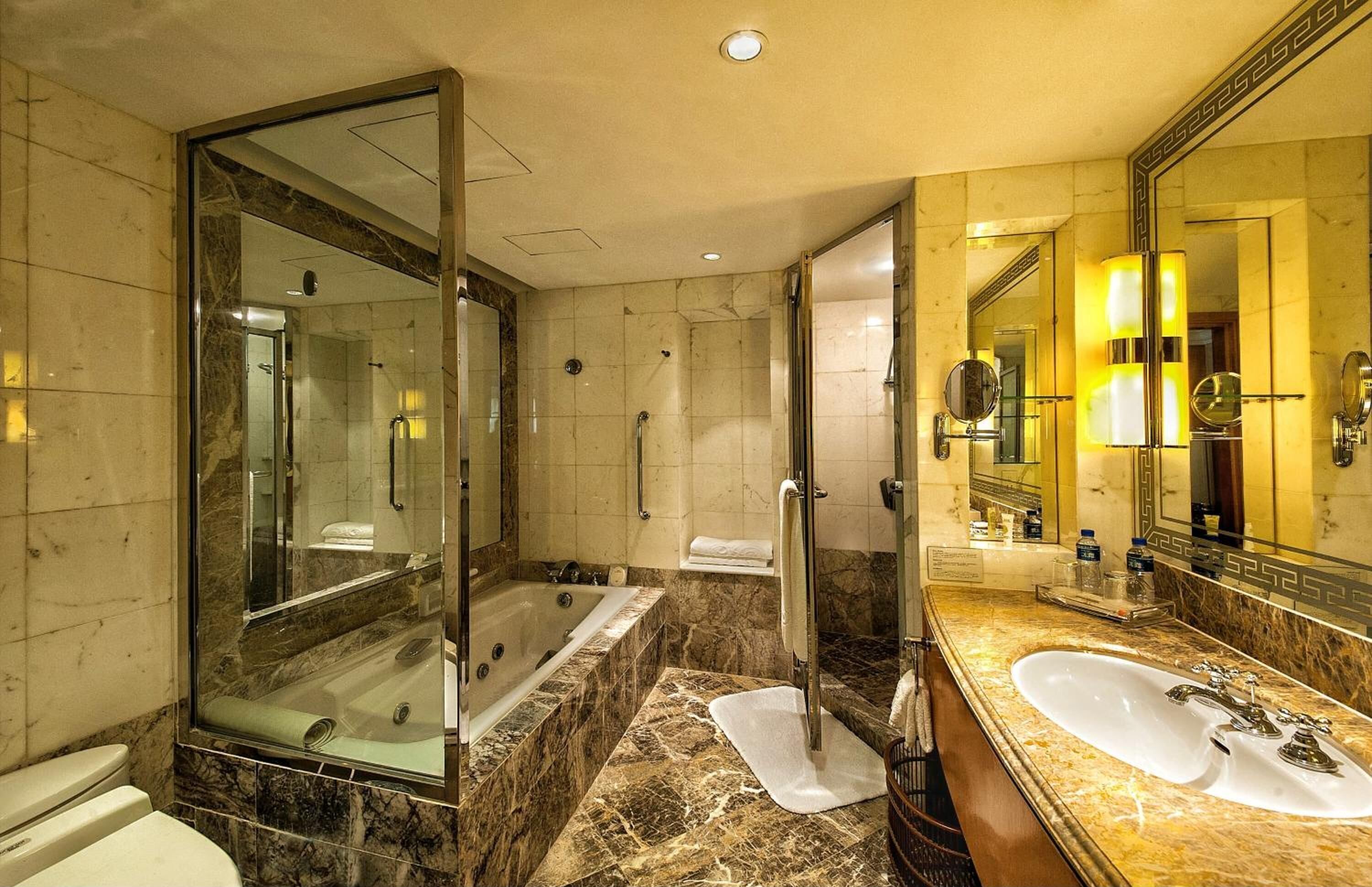 A modern bathroom with a large mirror, a bathtub, and a separate shower area.