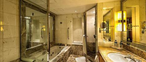 A modern bathroom with a large mirror, a bathtub, and a separate shower area.