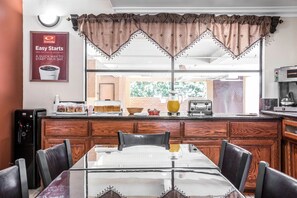 A breakfast bar with a coffee machine, a pitcher of orange juice, and a toaster. There is a sign advertising continental breakfast. - Econo Lodge Pico Rivera (Pico Rivera)