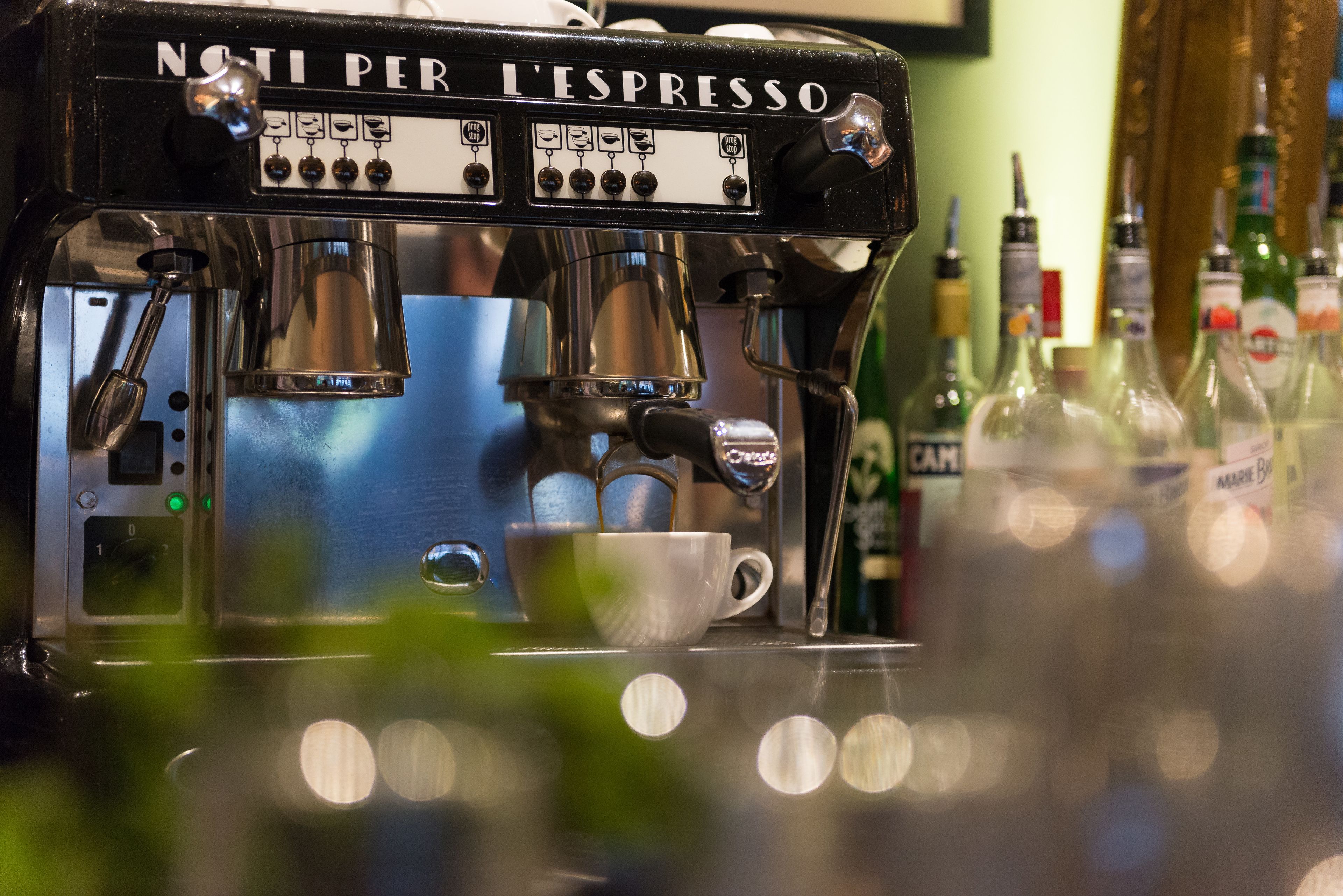 Een koffiemachine met een kopje eronder.