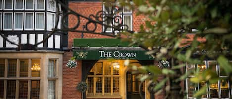 A traditional building with a green awning labeled "The Crown Manor House Hotel."