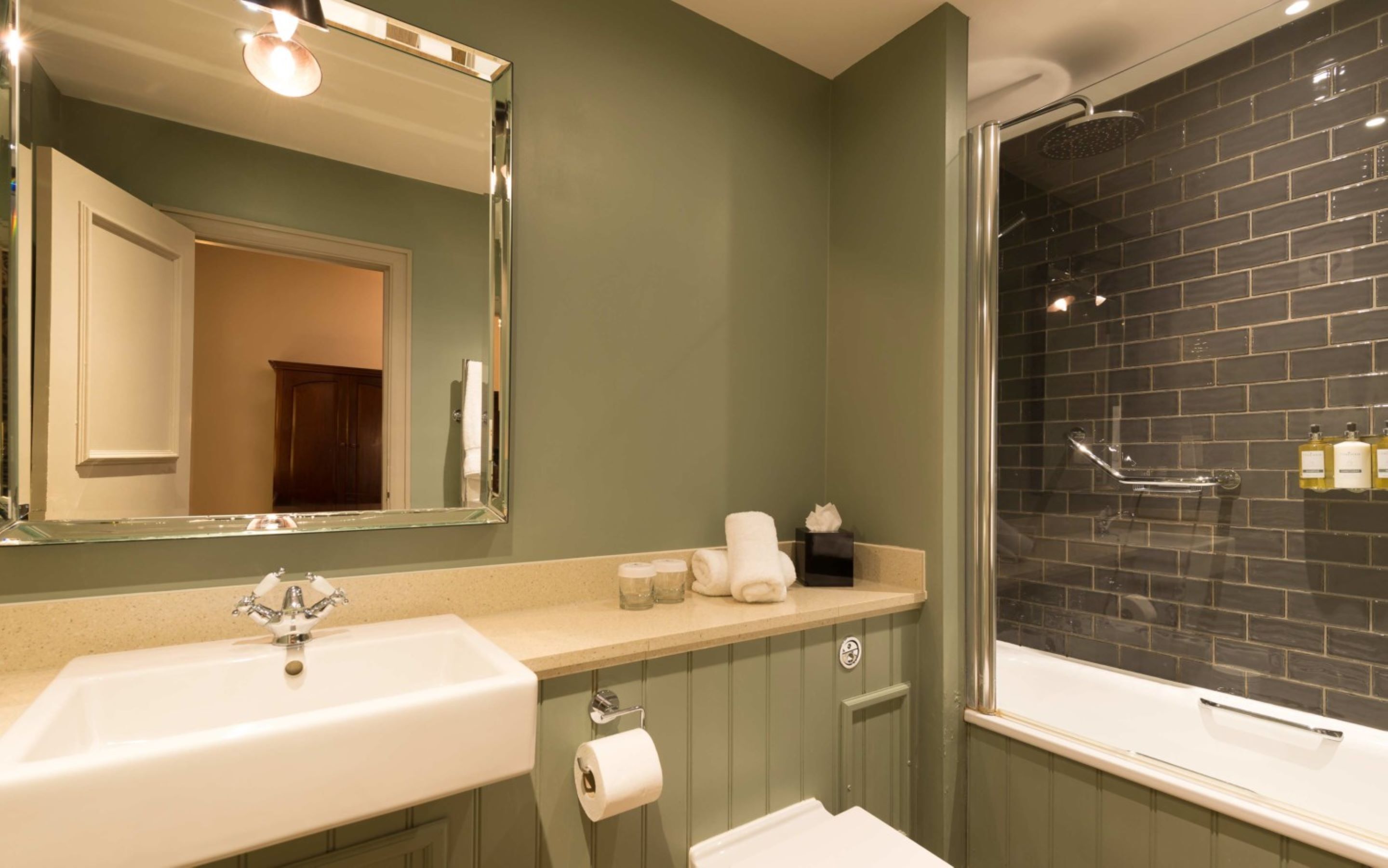 Une salle de bain avec un lavabo, un miroir et une douche.