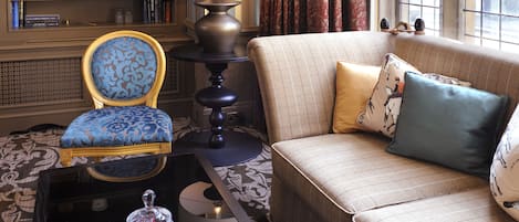 A well-furnished living room with a sofa, armchair, and a side table with a lamp.