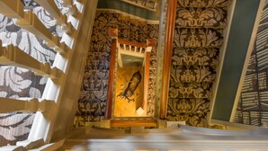 Una imponente escalera con elaborados diseños en la pared y una puerta de madera.