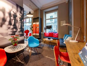 Un intérieur moderne avec un canapé, des fauteuils, une table et une grande fenêtre.