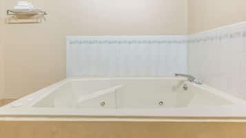 Une salle de bain avec une baignoire, un porte-serviettes et un mur carrelé.