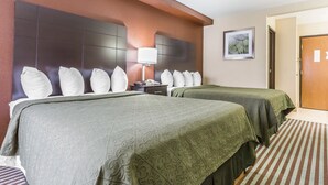 A hotel room with two beds, a nightstand, a lamp, and a framed picture on the wall. - Quality Inn Mount Vernon, IL (Mount Vernon)