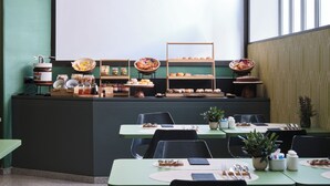 Un buffet de petit-déjeuner proposant diverses pâtisseries et un espace dédié au café.