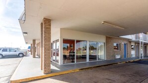 Un edificio con techo plano, fachada de ladrillo y entrada de vidrio.