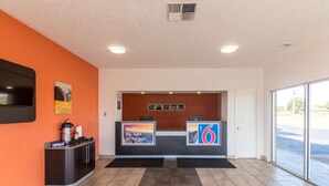 A reception area with a counter, a digital display, and a view of the parking lot. - Whitten Inn (Clinton)