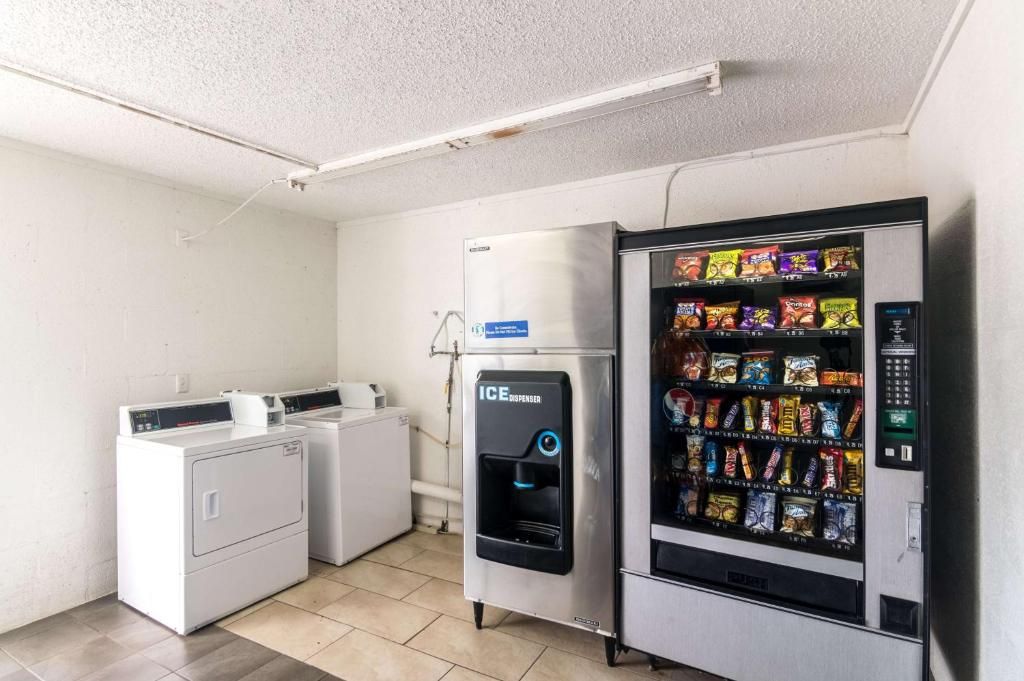 A laundry area with a washing machine, a dryer, and an ice dispenser vending machine.