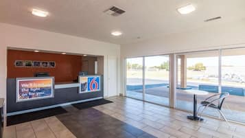 A reception area with a counter, a large window, and a view of the outside.
