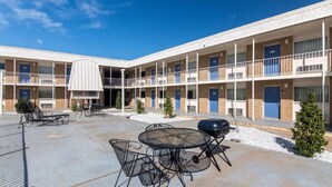 A multi-story motel with outdoor seating and a barbecue area. - Whitten Inn (Clinton)