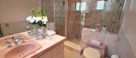 A bathroom with a sink, toilet, and shower.