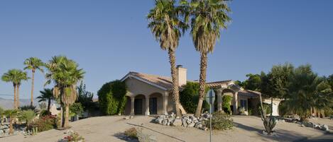 A house with a beige facade, arched windows, and a tiled roof.
