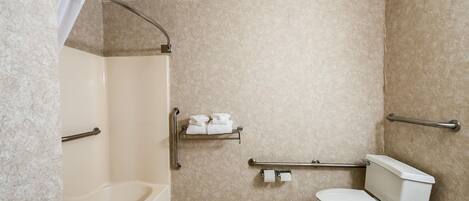 Een badkamer met een bad, toilet en douche.