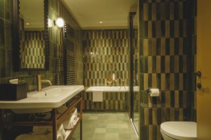 Un baño moderno con un espejo grande, dos lavamanos, una bañera y un inodoro.