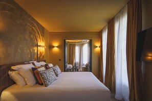 Relax in comfort with a large bed, dining table, and wall-mounted lamps.