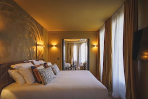 Relax in comfort with a large bed, dining table, and wall-mounted lamps.