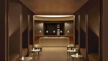 A modern, dimly lit hallway with a reception desk, seating area, and decorative lighting.