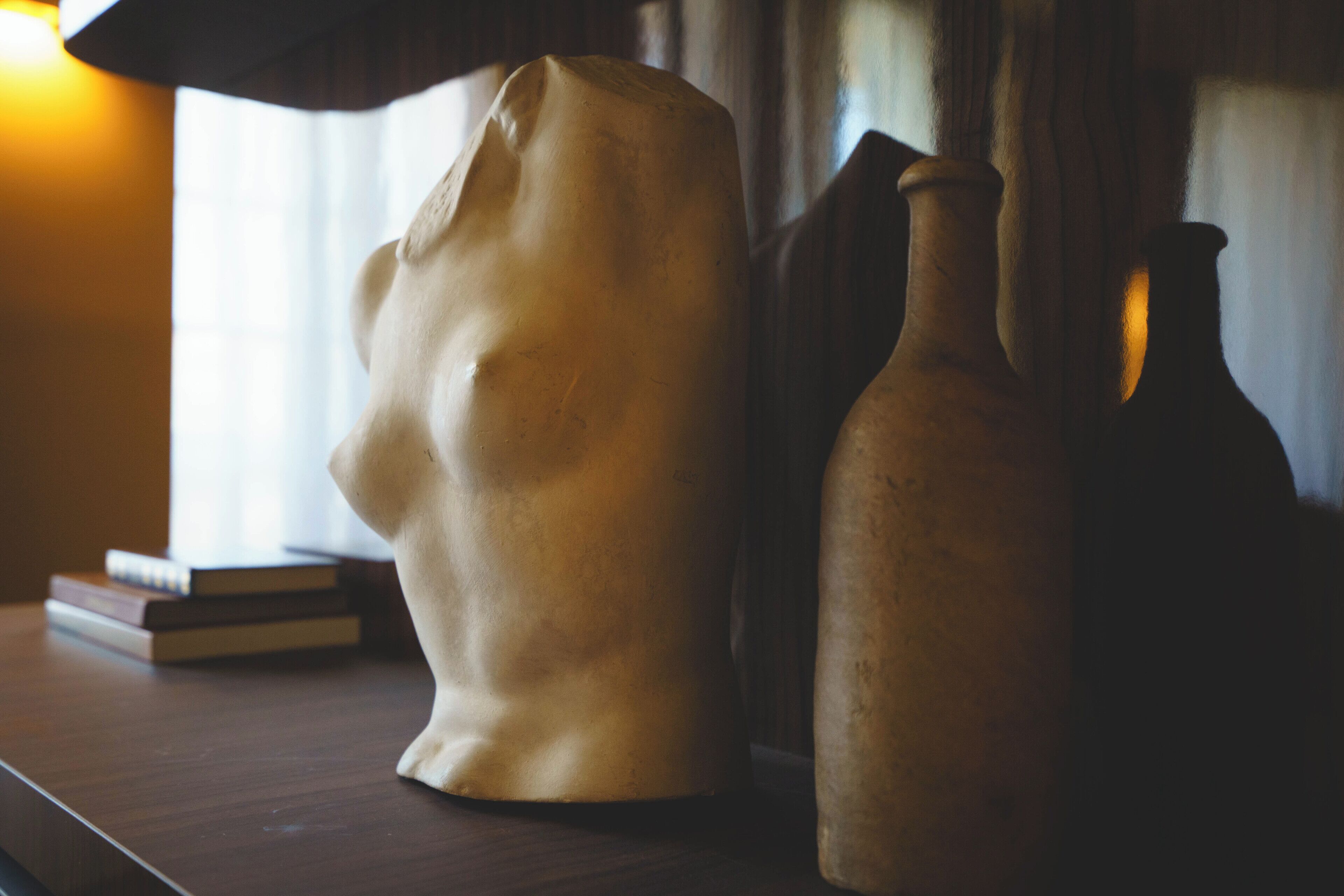 Une sculpture et deux vases sur une surface en bois.