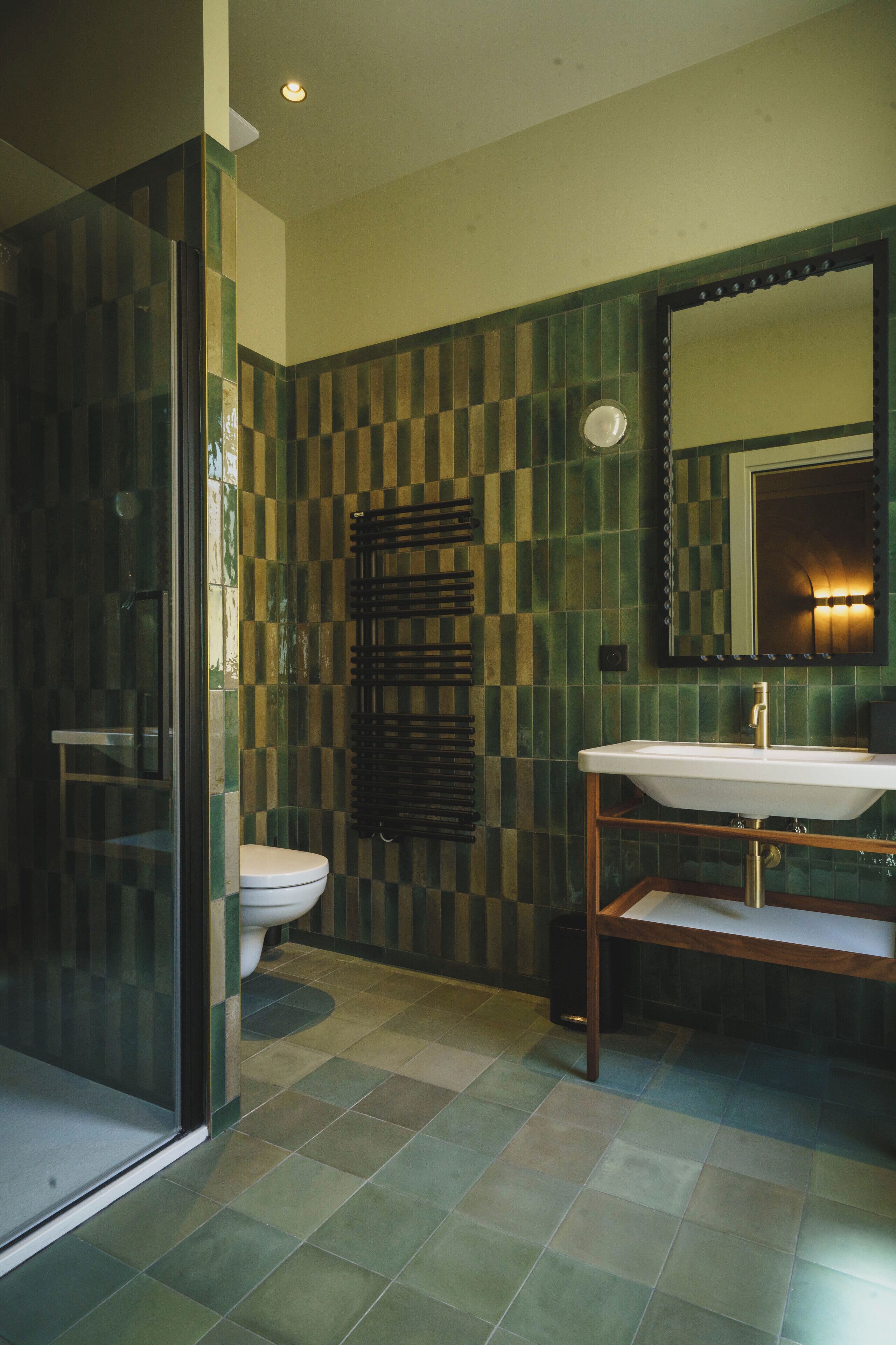 Un baño con cabina de ducha de vidrio, inodoro y lavabo con espejo.