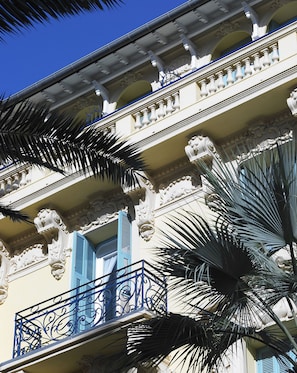 Stunning building with ornate detailing and blue accents, set amidst lush palm trees.