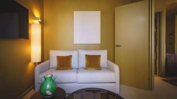 A room with a sofa, a lamp, a vase, and a door.