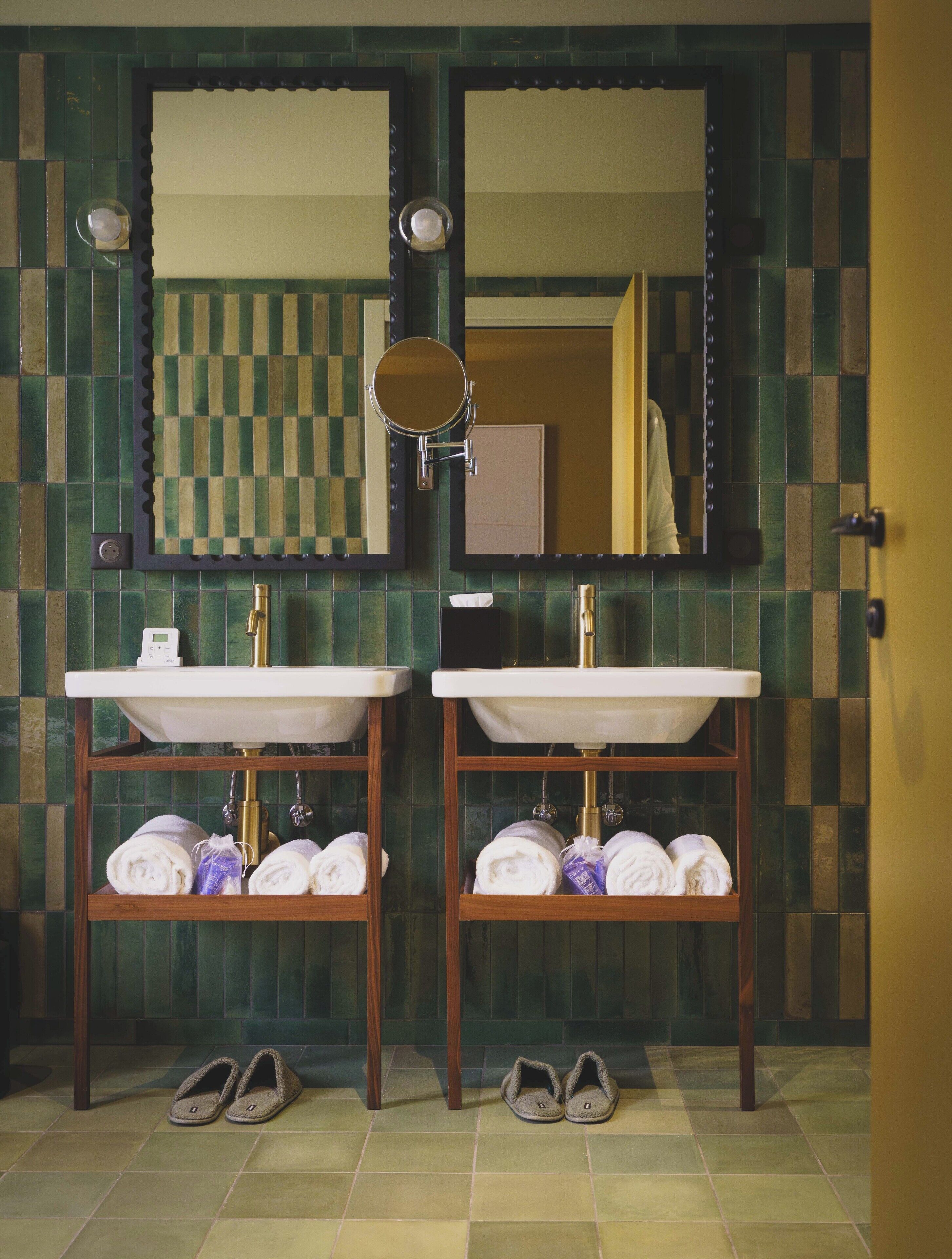 Ein Badezimmer mit zwei Waschbecken, einem Spiegel und einem Handtuchhalter.