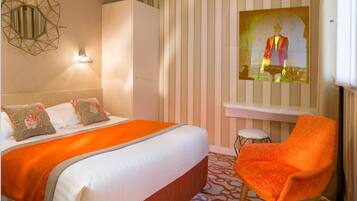 Une chambre d’hôtel avec un lit, une chaise, un bureau et un tableau accroché au mur.