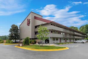 A Red Roof Inn with a modern design, featuring a parking lot and a landscaped area with trees and shrubs. - Red Roof Inn Asheville - Biltmore West (Asheville)