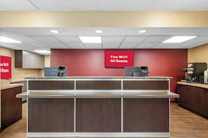 A hotel lobby with a reception desk, a coffee machine, and a sign indicating free Wi-Fi in all rooms. - Red Roof Inn Asheville - Biltmore West (Asheville)